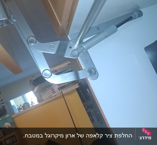 מנגנון פתיחת ארון במטבח עם רקע של חדר